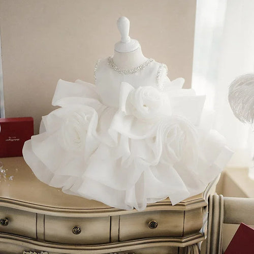 Elegant white flower girl dress with a floral design and faux pearl accents, perfect for baptism and christening ceremonies from our collection of baptism, christening, and flower girl dresses.