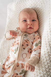Close-up of beige zipper guard and soft bamboo fabric texture on cowgirl print onesie