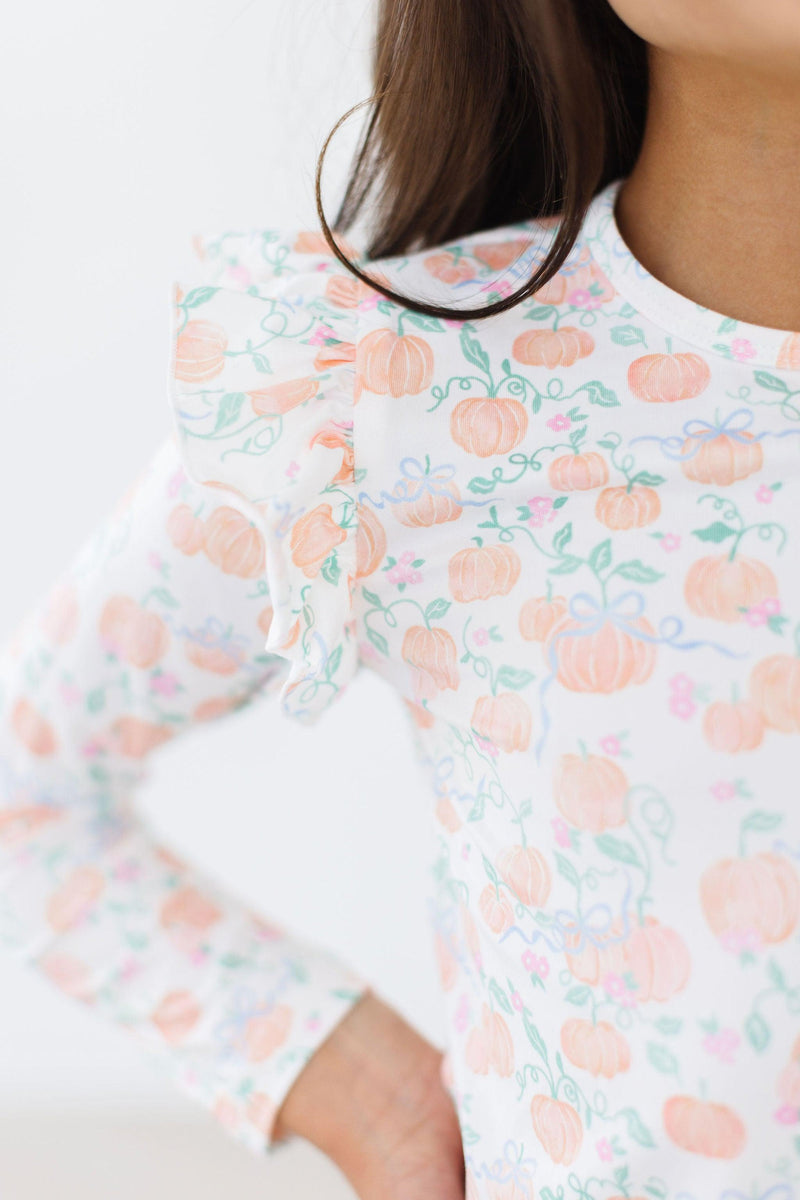 Close-up of the Pretty Pumpkins L/S Ruffle Tee highlighting the soft fabric and ruffled detail, featuring a colorful pumpkin pattern.