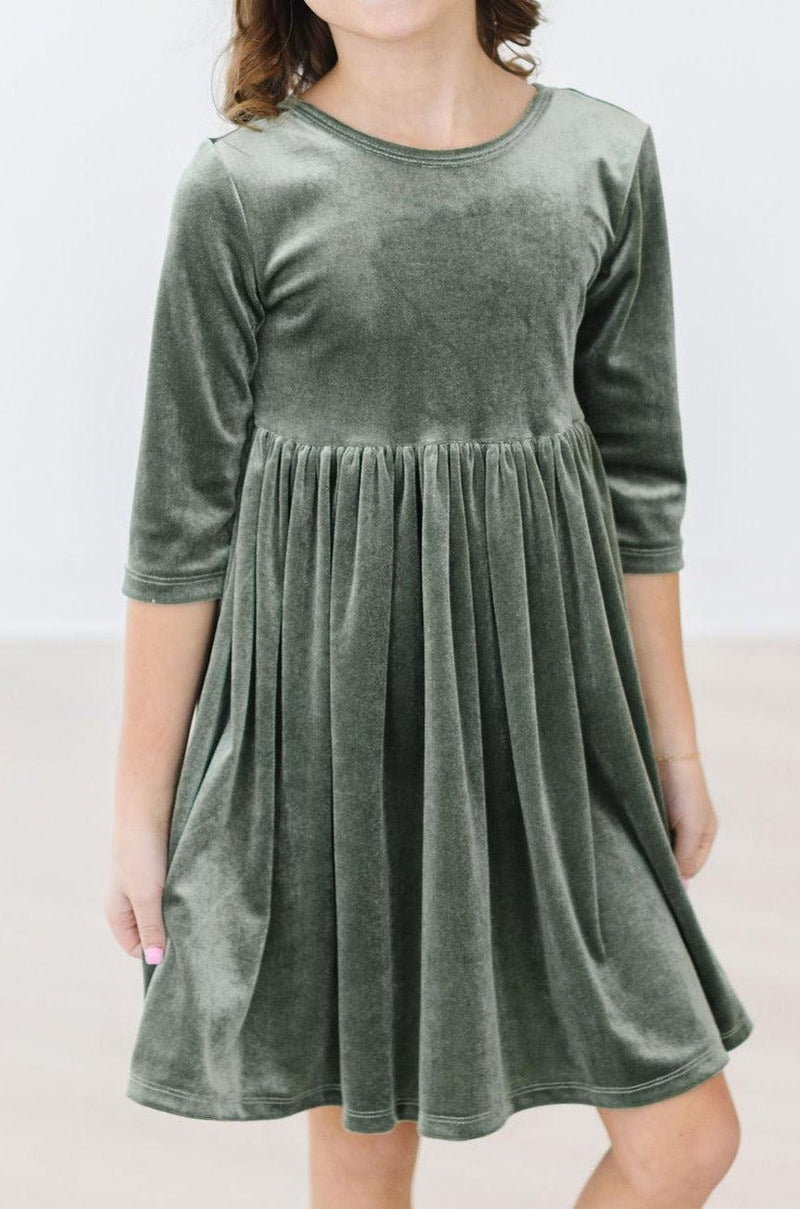 Sage Velvet Twirl Dress by Mila & Rose®, featuring a girl wearing a soft green velvet dress with a full skirt, perfect for twirling and play.