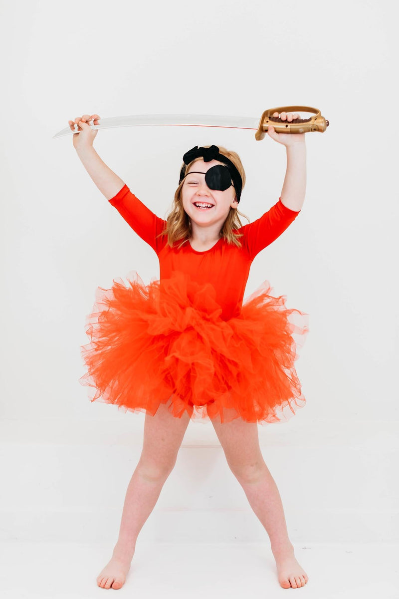 A joyful child dressed as a pirate in a Festive Red 3/4 Holiday Fluffy Tutu Leotard for Girls, waving a sword and wearing an eye patch, featuring the versatility and fun elements of the tutu design.