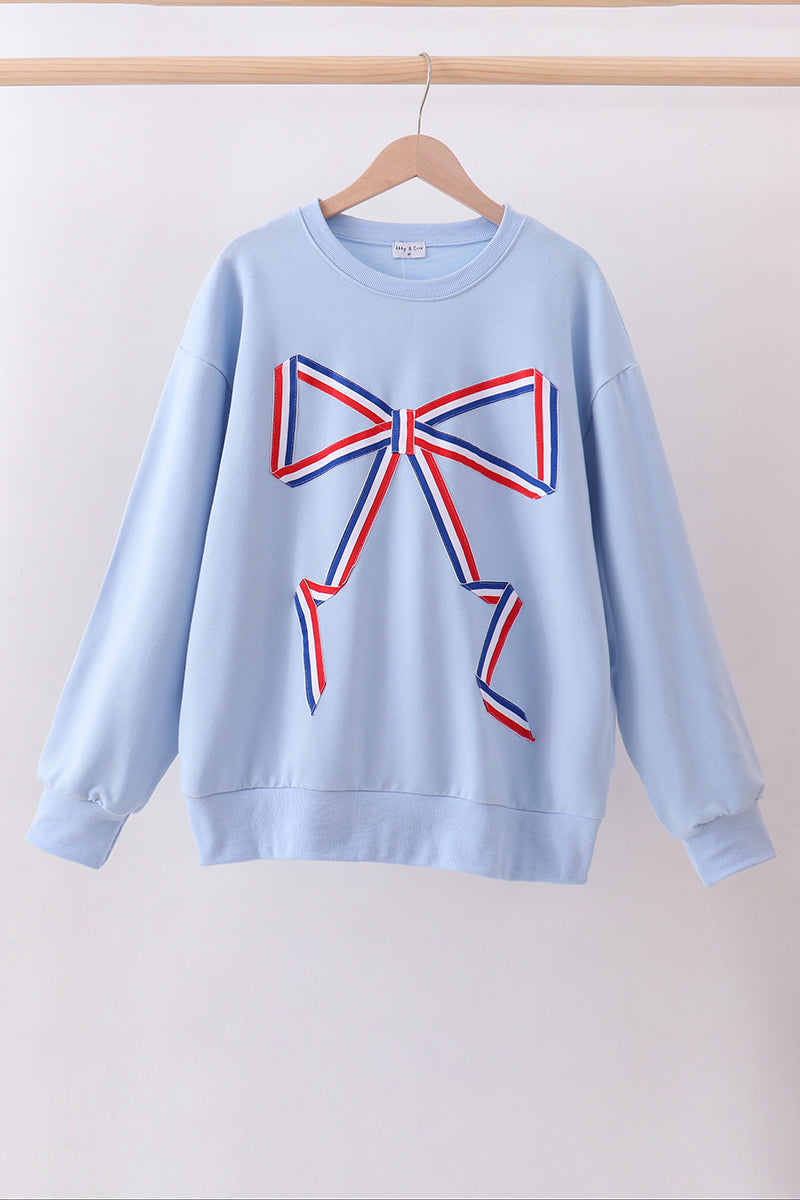 Light blue sweatshirt with a large red and blue bow design on a white background
