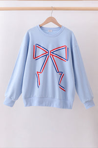Light blue sweatshirt with a large red and blue bow design on a white background