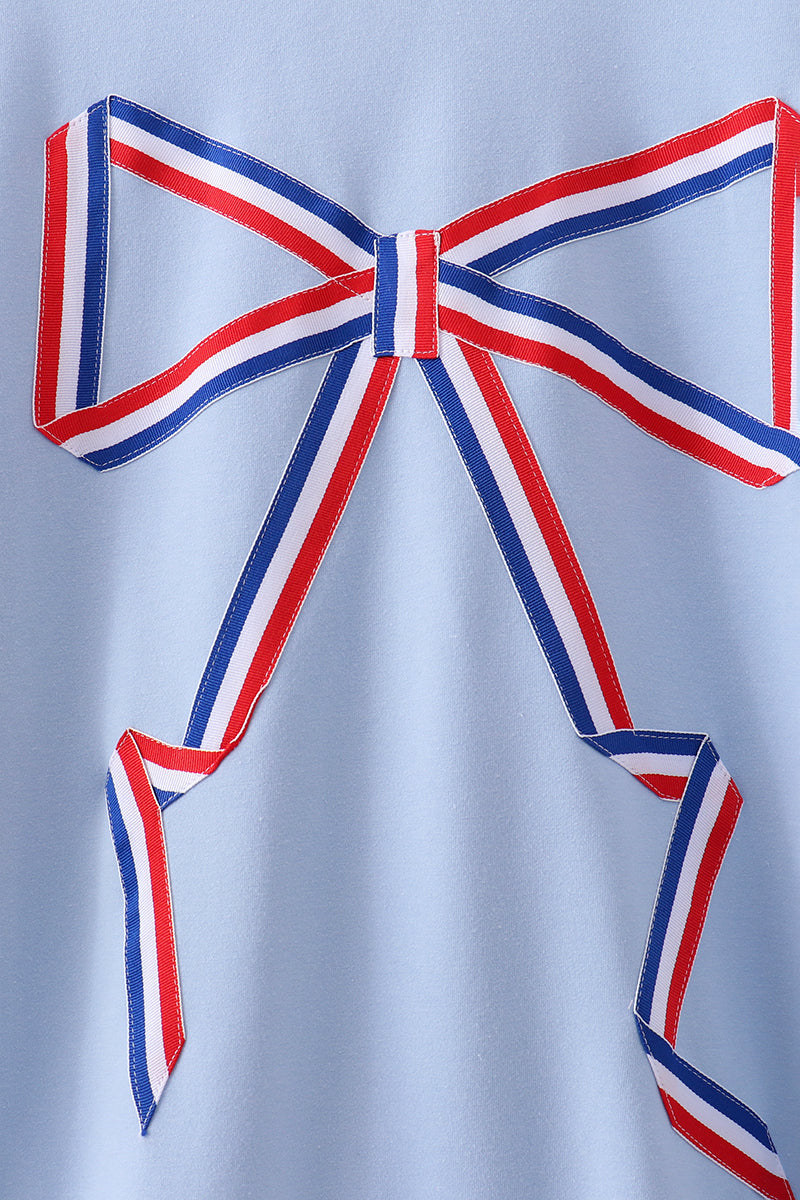 Large red, white, and blue bow on a light gray background
