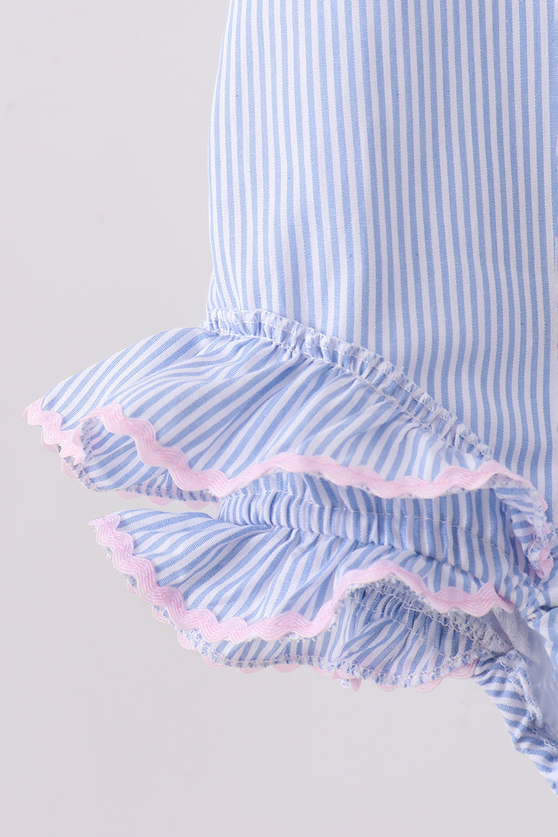 Blue and white striped dress with ruffled hem on a light gray background