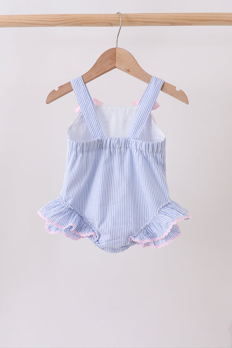 Blue and white striped baby romper with ruffles on a wooden hanger against a white background