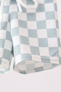 Checkered shirt with light blue and white pattern on a plain background