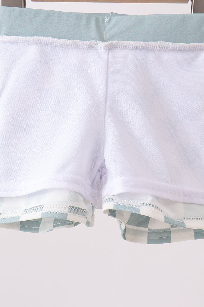 Close-up of a white shirt with blue plaid trim on a light background