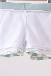 Close-up of a white shirt with blue plaid trim on a light background