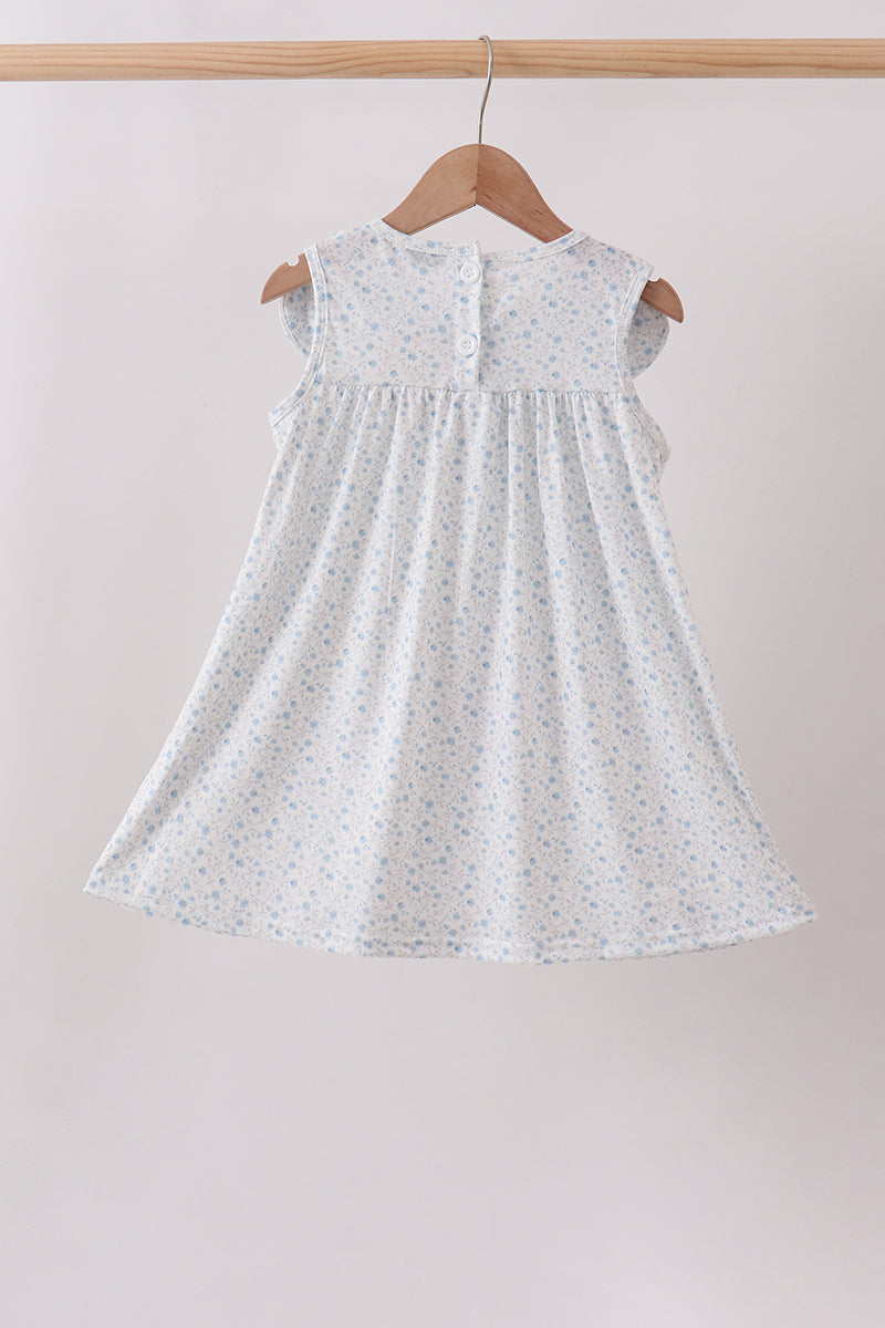 White dress with subtle pattern on a wooden hanger against a plain background