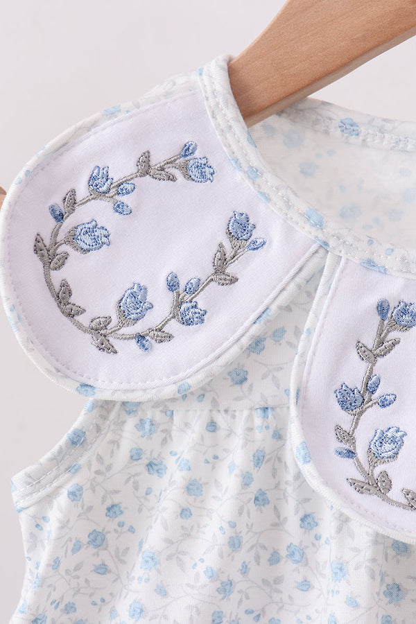 Pair of white oven mitts with blue floral embroidery on a matching towel.