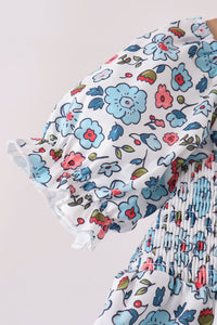 Blue floral girls dress with smocked bodice and ruffled puff sleeve detail.