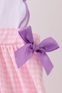 Purple satin bow detail on pink gingham skirt of puppy pumpkin applique dress for fall festivities and Halloween.