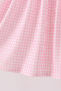Pink gingham fabric detail from a puppy pumpkin applique dress, featuring soft folds and hem stitching for fall wear.