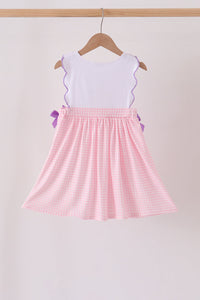 Pink gingham applique dress featuring white ruffled top, purple trim, and side bows for fall festivities.
