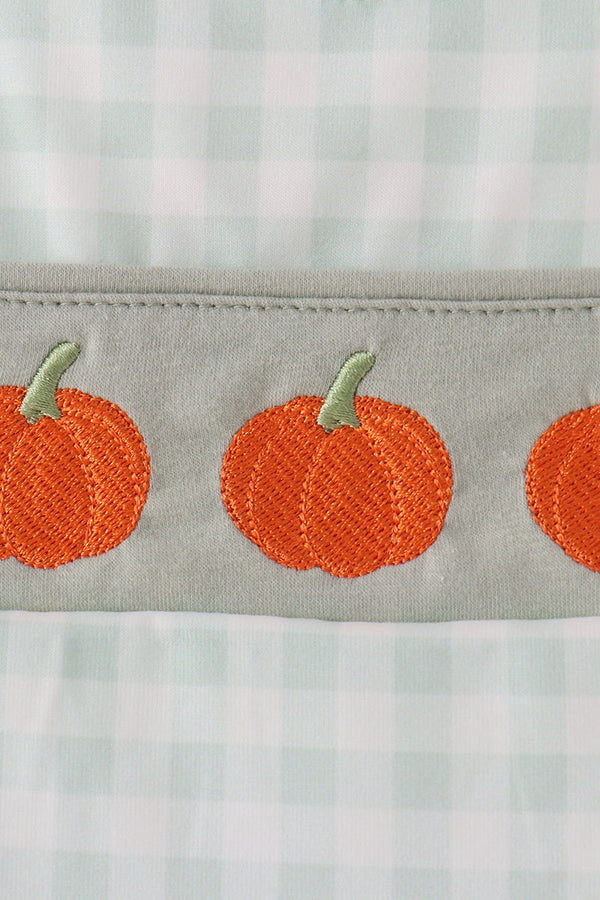 Sage green gingham fabric trim featuring embroidered orange pumpkins with green stems on a baby romper.