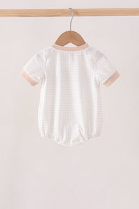 Back view of white gingham bubble with pink trim hanging on wooden hanger. Soft casual infant onesie with short sleeves and snap crotch.