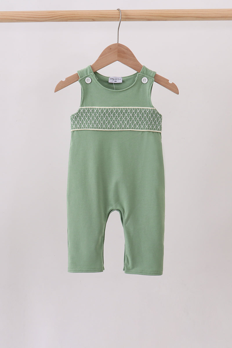 Sage green smocked jon jon romper for babies with white lattice smocking across chest, on a wooden hanger.