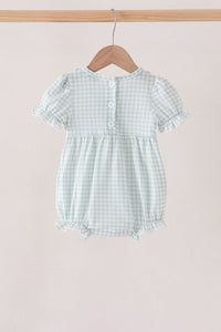 Back view of sage gingham bubble romper with ruffle sleeves, button closure, and comfortable silhouette on wooden hanger.