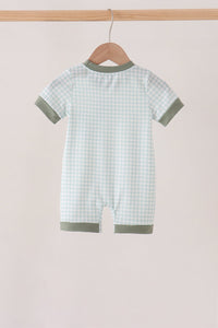 Back view of sage green gingham romper with solid trim on a hanger. Soft cotton baby one-piece with fitted bodice and relaxed legs.