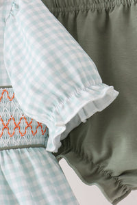 Sage gingham baby top with orange smocking and ruffle sleeve beside olive pumpkin bloomer shorts with elastic waist.