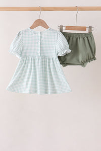 Back view of sage gingham baby bloomer set with ruffled sleeves and solid sage bloomers on hanger.