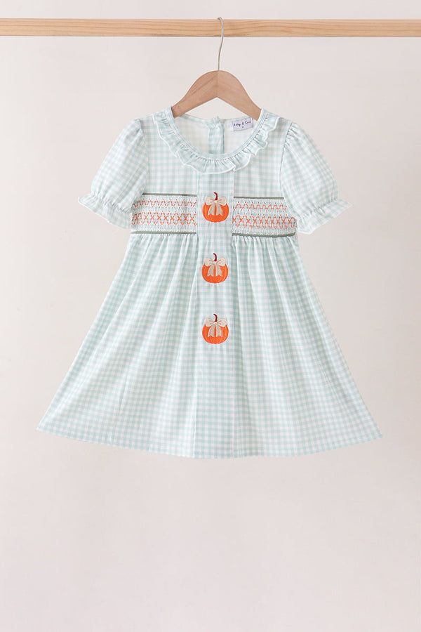 Sage pumpkin smocked gingham dress with ruffled neckline, short puff sleeves, and three embroidered orange pumpkins down the front.