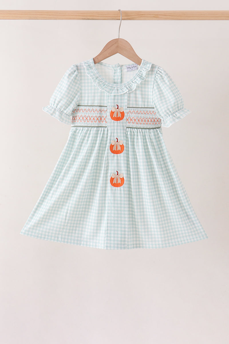 Sage pumpkin smocked gingham dress with ruffled neckline, short puff sleeves, and three embroidered orange pumpkins down the front.