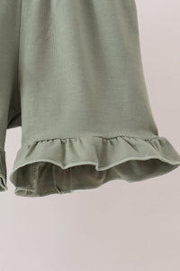 Sage ribbed knit shorts featuring a delicate ruffled hem detail for a comfortable and stylish children's outfit.