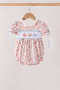 Floral print baby bubble outfit with embroidered pink, beige, and blue pumpkins on white chest band and ribbon tie sleeves.