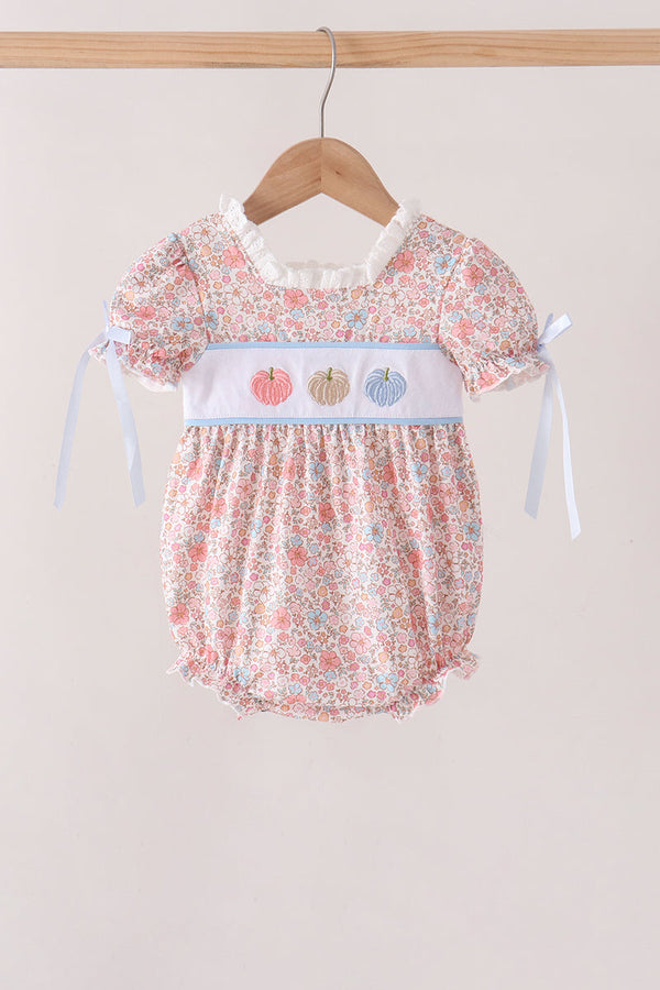 Floral print baby bubble outfit with embroidered pink, beige, and blue pumpkins on white chest band and ribbon tie sleeves.