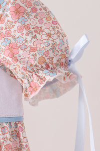 Pink floral bubble sleeve with ruffled cuff and light blue ribbon tie, featuring delicate pink and blue flower print.
