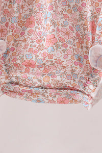 Pink floral bubble dress with snap buttons, featuring a delicate pastel flower print on soft fabric for seasonal comfort.
