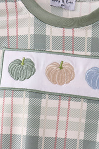 Green pumpkin embroidery on plaid fabric detail of a cozy baby bubble gown with festive fall charm.