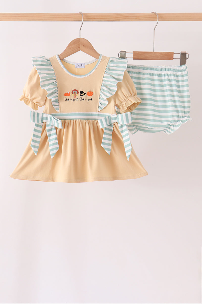 A baby girl's two-piece outfit set hanging on wooden hangers against a plain light background. The set includes a short-sleeve ruffle dress in pale yellow with mint green and white striped ruffle sleeves, a matching bow at the waist, and a pair of matching mint green and white striped bloomers.