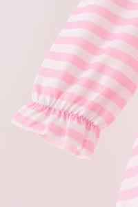 Close-up of a pink and white striped fabric sleeve with a gathered ruffled cuff, shown against a pale pink background.