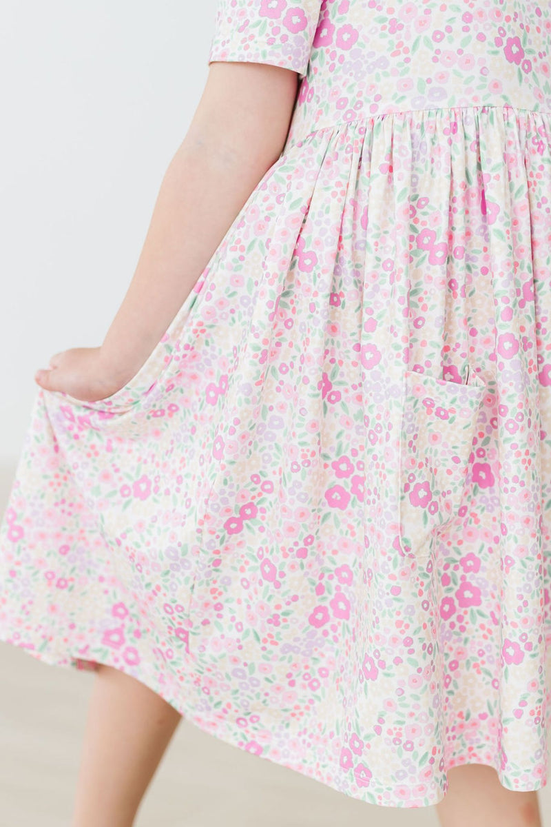 Child wearing the Blooming Beauty S/S Pocket Twirl Dress, demonstrating its versatility for outdoor play and special events.