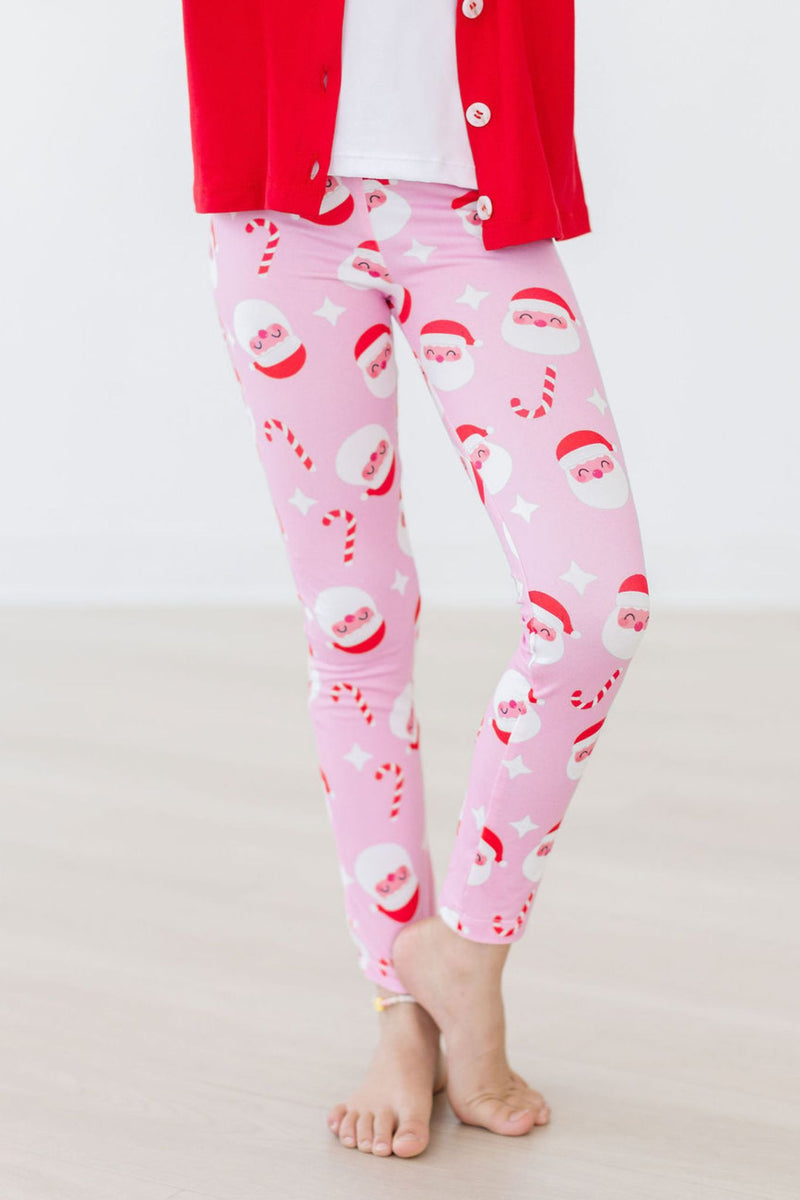Jingle Bells Leggings featuring a playful Santa Claus design in pink, perfect for the festive season, showcased on a young girl wearing a red cardigan.