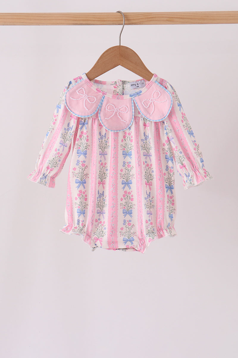 Pink and white striped baby romper with floral bouquets hanging on a wooden hanger