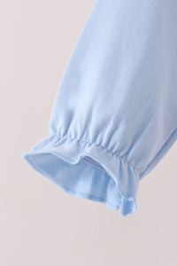 Light blue ruffled cuff detail on soft children's two-piece pumpkin set for fall.