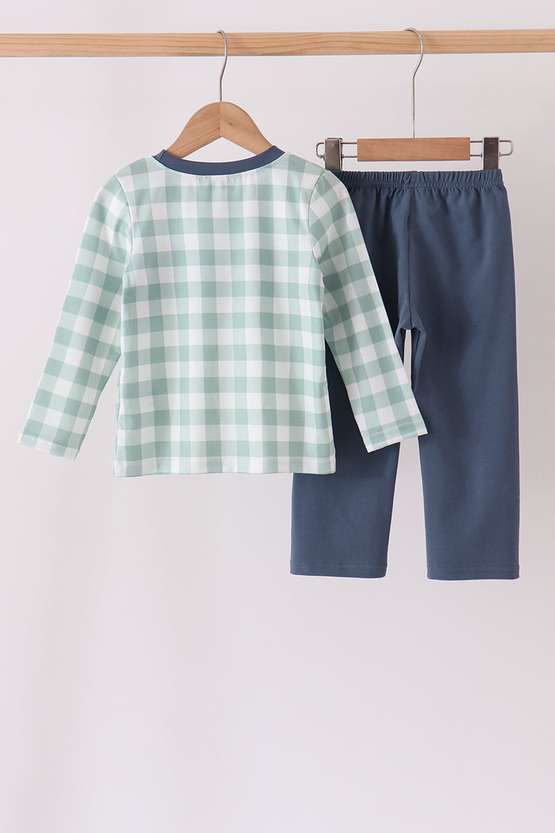 Back view of sage green and white checkered shirt with plain navy blue trousers