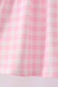 Pink and white gingham fabric texture for baby bloomers, featuring soft folds and neat hem stitching for vintage-inspired children's wear.