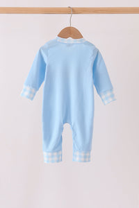 Back of light blue baby romper with gingham cuffs and legs, hanging on a wooden hanger.
