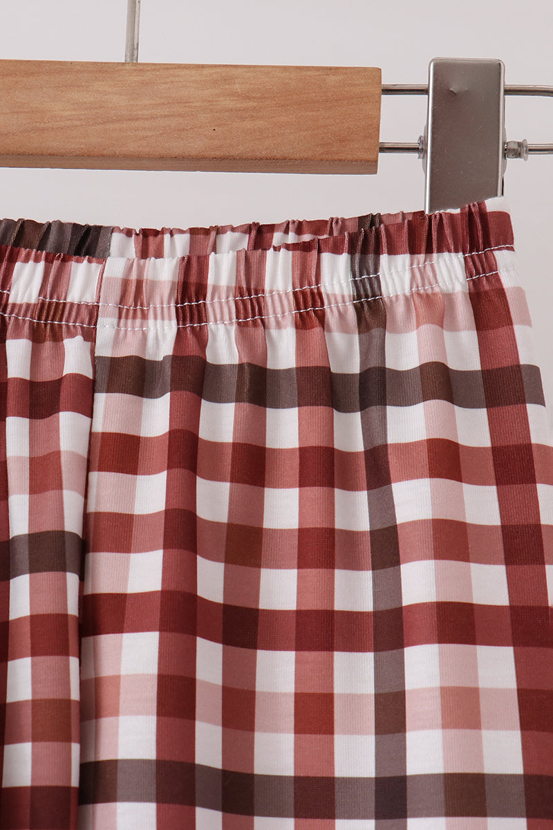 Close-up of elastic waistband on rust brown and white plaid children's pajama pants