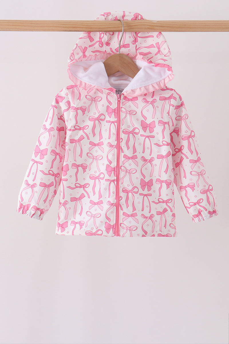 White hooded raincoat with pink bow and star pattern, ruffled hood trim, and central pink zipper on wooden hanger