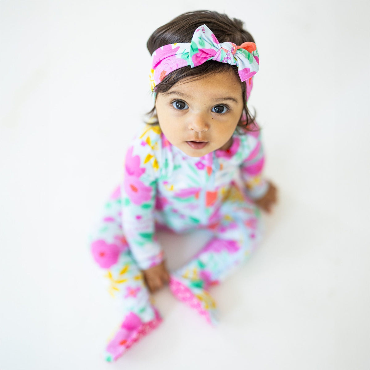 The SoftKnot Baby Bow Head Wrap - Babies and Toddlers - Flower Power. Demonstrating the head wrap's gentle design that avoids red marks or slipping.
