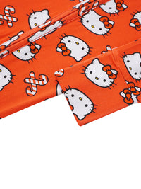 Macro detail of orange bamboo fabric texture with white Hello Kitty illustrations and black whiskers.