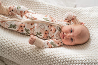 Angled view of convertible foot design and stretchy fit of cowgirl print bamboo romper