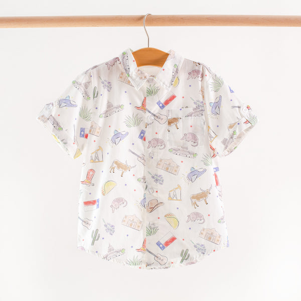 Texas Kids short sleeve collared shirt with print of cowboy hats, longhorns, boots, tacos, guitars, armadillos.
