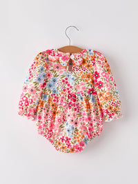 Colorful floral baby girl romper with long sleeves and back button closure, displayed on hanger.